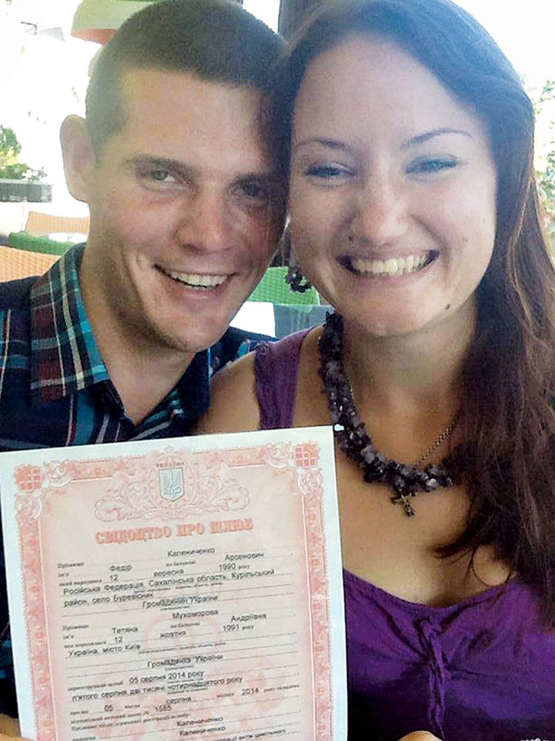 Fedir and Tetiana Kalenychenko boast their brand new marriage certificate on Aug. 5, 2014. 