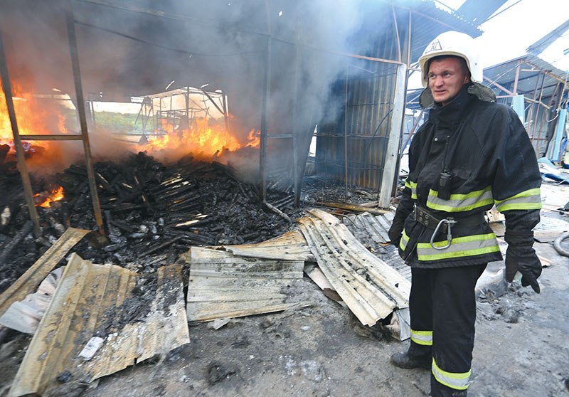 A firefighter extinguishes a blaze at a market in Russian-controlled Donetsk after shelling between Ukrainian forces and Russian-separatist forces on June 3.