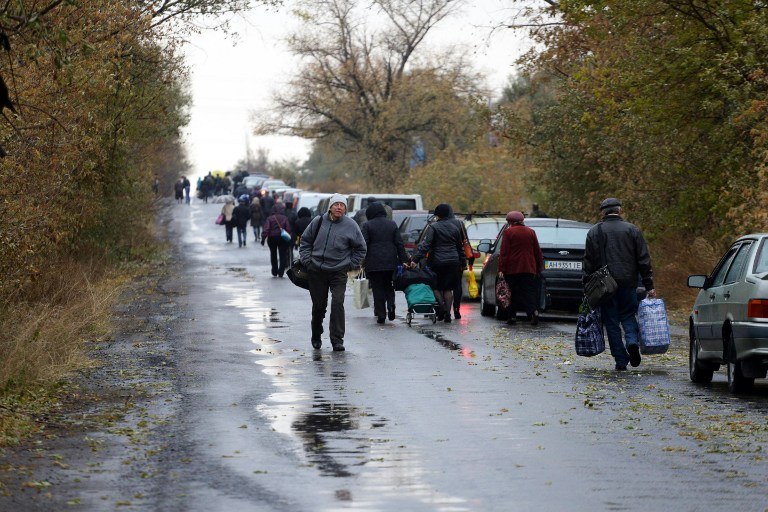 People queue at checkpoint of Zaytseve, Donetsk region on October 23, 2015, to cross the demarcation line between territory controlled by pro-Russian separatists and Ukrainian territory. 