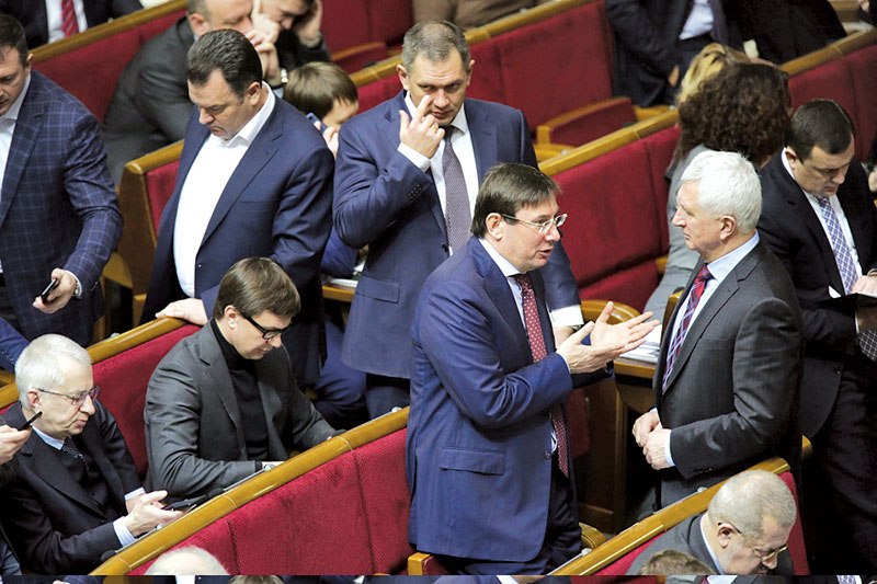 Lawmaker Yuriy Lutsenko (center, glasses), head of President Petro Poroshenko’s parliamentary faction, speaks to a colleague on Jan. 28 in the legislative chamber. (Ukrafoto)