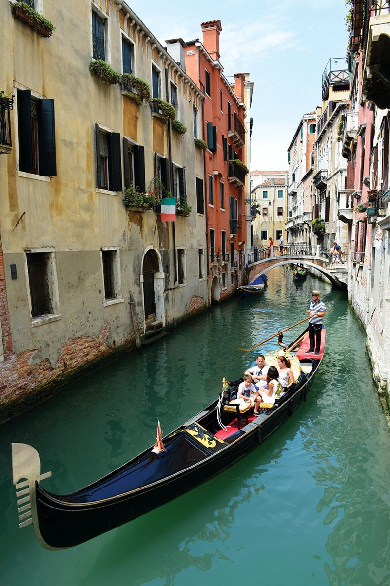Tourists enjoy a gondola ride near St. Mark’s Square in Venice, Italy.