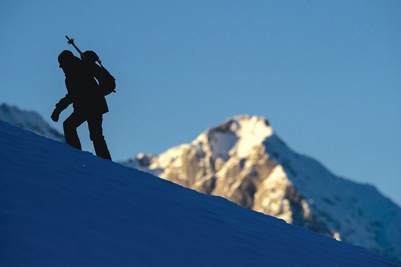 A tourist climbs a hill near the slalom course track of the FIS Ski World Cup in Kitzbuehel, Austria on Jan. 22. (AFP)