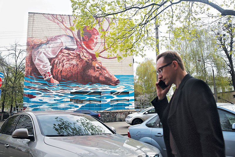 A man walks past “The River Crossing” mural on 19/22 Voloska St. on April 11 in Kyiv. 