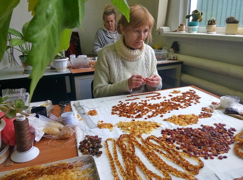 In late April, 2016, a jewelry worker strings together amber beads to make a necklace at Burshtyn Ukrainy, a state-owned company based in Rivne. 