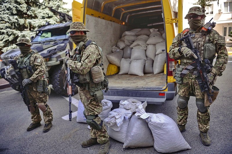 The armed policemen stand next to the sacks with some 2,640 kilograms of the illegally extracted amber by the office of Minister of Interior Affairs in Kyiv on Aug. 4, 2015.