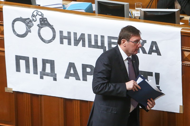 Prosecutor General Yuriy Lutsenko walks to the tribune in front of a poster that reads "Arrest Onyshchenko" at a parliament meeting on July 5.