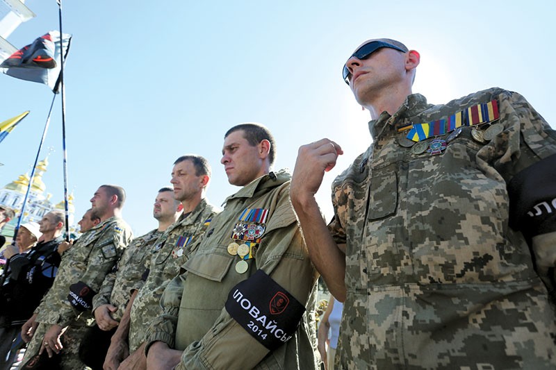Ukrainian soldiers pray on Aug. 29 for their comrades who were killed during the battle of Ilovaisk in the Donbas in August 2014. (Anastasia Vlasova)