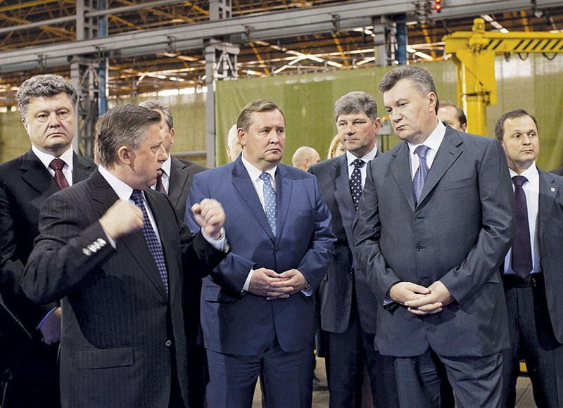 Petro Poroshenko, then economy minister (at far left) and then President Viktor Yanukovych (front, right) are at the Transmash factory in Luhansk on Oct. 16, 2012. Poroshenko served as economy minister for nine months during Yanukovych’s presidency. 
