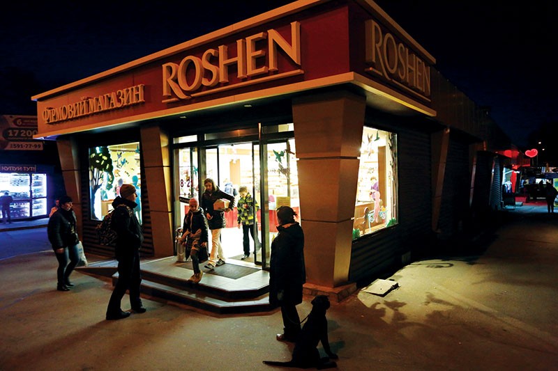 Above left): A customer leaves a recently opened Roshen outlet near Zhytomyrska metro station in Kyiv on April 14, 2015. The Roshen confectionary is part of Poroshenko’s business empire. 