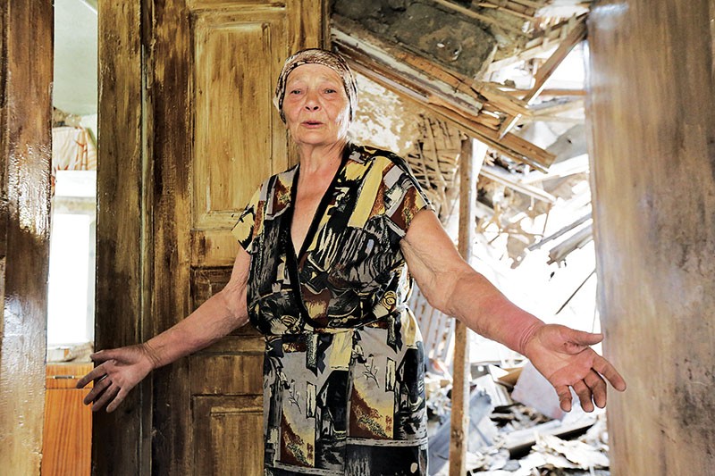 A woman shows one of the rooms in her house destroyed by severe shelling which continued for 13 hours on June 3, 2015, in Maryinka during an attempt to take over the town. (Volodymyr Petrov)