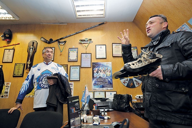 Canadian Ambassador to Ukraine Roman Waschuk (C) talks to Serhiy Tymofeyev (R), a head of the skating rink that's located in Obolon district where Sokil Youth Ice Hockey School trains.