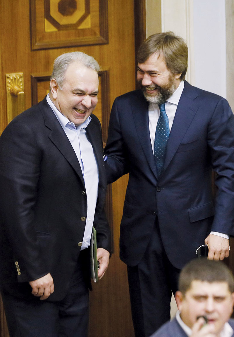 Vadim Novinsky (R) laughs with fellow lawmaker David Zhvania in parliament on Oct. 24, 2013. At that time both were members of the Party of Regions faction which backed then-President Viktor Yanukovych. (UNIAN)