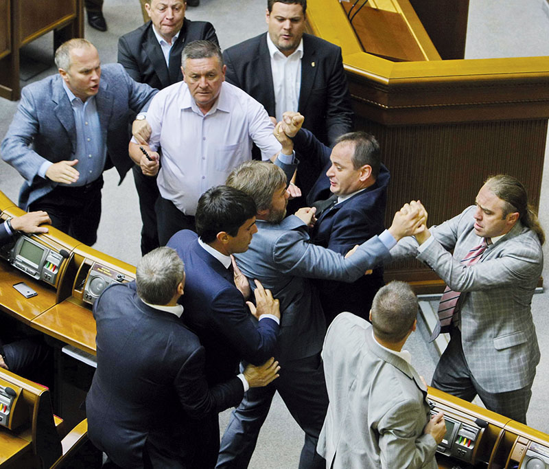 Supported by fellow lawmakers from the Party of Regions, Vadim Novinsky (C) is seen in this June 22, 2014 photograph fist fighting with legislators from the nationalist Svoboda party. (Ukrinform)