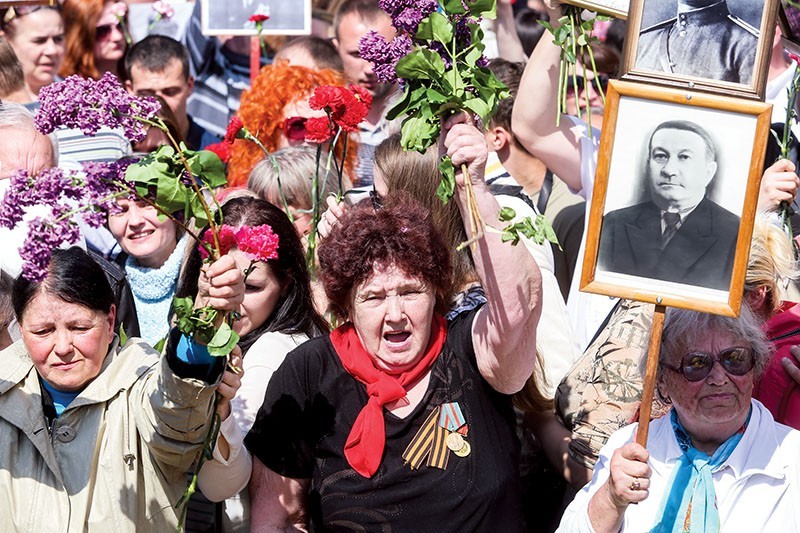 Relatives of Soviet soldiers from World War II march brandishing the portraits of their veteran and fallen relatives on May 9, 2016, in Kyiv during the rally called the “Immortal Regiment.” The controversial rally, whose idea was borrowed from Russia, sparked big criticism in Ukraine. (Koslyantyn Chernichkin)