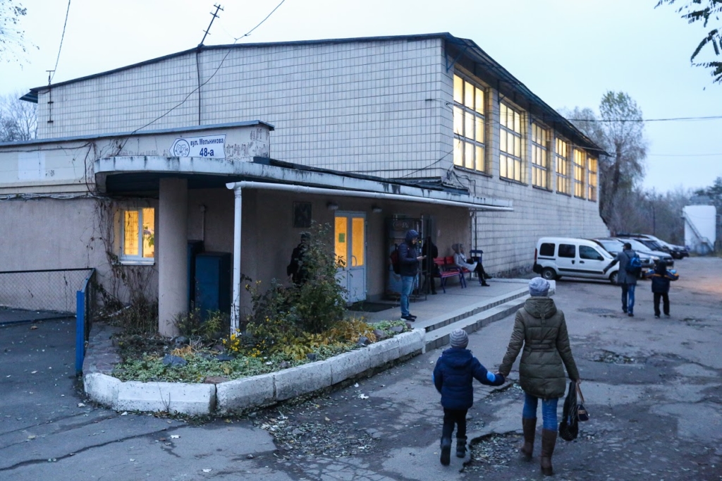 Parents walk the children near Avangard Ice Rink Arena in Kyiv. 