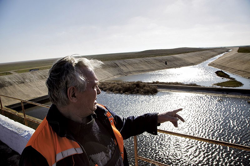 Viktor Kuminov, the hydro engineer who works at Northern Canal Pumping Station N358 points out to the rain water in the canal. The main source of water for the peninsula, the Northern Crimean Canal, was cut of from water supplies since 2014.
