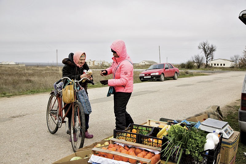 A woman buys bananas at a local market in the village of Alexeyevka in northern Crimea on Nov. 11. The region’s agriculture has been hard hit by water shortages since Ukraine cut supplies from the Dnipro River in the wake of Russia’s 2014 invasion and annexation of the territory. 