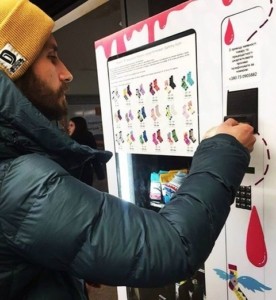 A man buys socks out of the Sammy Icon vending machine.