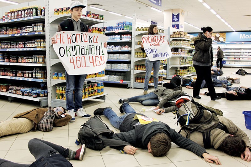 Vidsich Civic Movement activists hold posters calling for a boycott of trade with Russia – which has the product code 460 -- as other protesters lie on the floor in one of Kyiv supermarkets during a “Russian-made Kills” performance in 2014. (Courtesy of Vidsich)