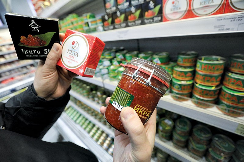 A customer examines country-of-origin identifying codes of caviar in a Kyiv supermarket on March 22. Caviar was included in the list of banned Russian goods by the Ukrainian government in 2015. However, experts say Ukrainian businessmen keep buying it from Russia as raw material and repackaging it as “Made in Ukraine.” (Volodymyr Petrov)