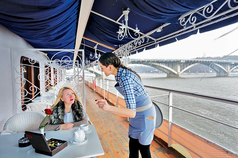 A waitress takes orders from a visitor of Grand Piano Café on March 24. The restaurant perches on the first floor of Bakkara Hotel and offers a wonderful view on Kyiv-Pechersk Lavra domes and the gigantic Mother Motherland Monument. (Anastasia Vlasova)