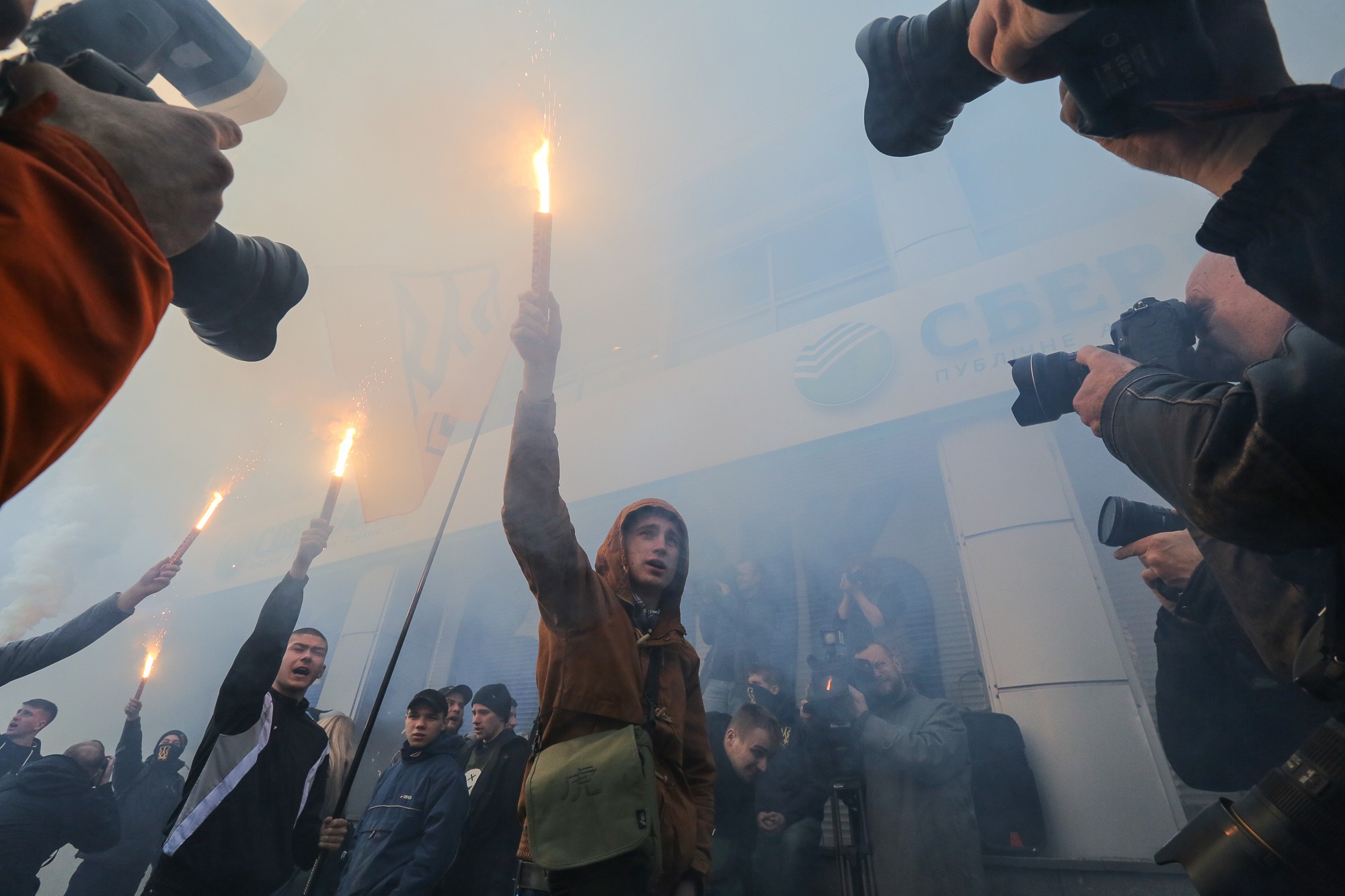 National Corps activists burn flares as they came to the Sberbank to close it with a concrite brick wall in order for Sberbank to stop its activity in Ukraine during their rally on March 13. (2017) 