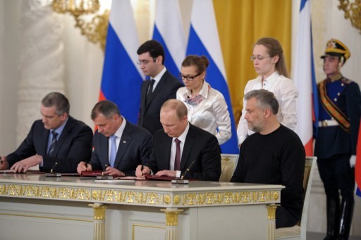 Russia's President Vladimir Putin (2nd R), Crimean Prime Minister Sergei Aksyonov (L), Crimean parliament speaker Vladimir Konstantionov (2nd L) and Alexei Chaly, Sevastopol's new de facto mayor (R), sign a treaty on the Ukrainian Black Sea peninsula becoming part of Russia in the Kremlin in Moscow , on March 18, 2014. Putin pushed today every emotional button of the collective Russian psyche as he justified the incorporation of Crimea, citing everything from ancient history to Russia's demand for respect to Western double standards.