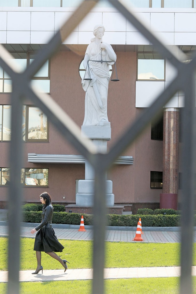 A woman walks by the statue of Lady Justice outside of Kyiv Appeal Court on April 4. (Kostyantyn Chernichkin)