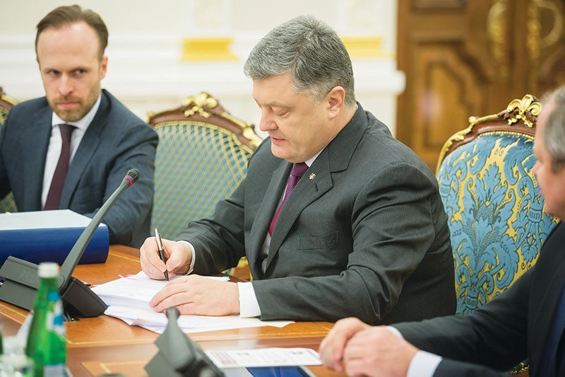 Oleksity Filatov, deputy head of the Presidential Administration in charge of judicial reform, looks on as  President Petro Poroshenko signs papers during a March 22 session of the Judicial Reform Council in Kyiv. (Mikhail Palinchak)