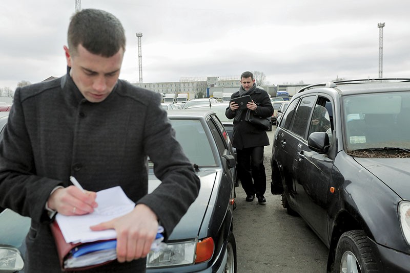 Sergey Makarenko (R) and Anatoliy Televskiy, state executors in Kyiv, register cars in March. Ukraine is in the early stages of having a private executor service. The first batches of executors are in training and set to execute their first orders by mid-May. 