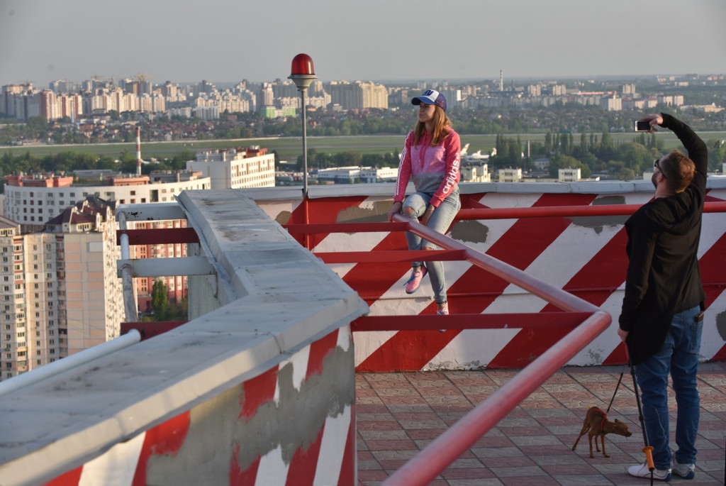 A woman poses for a photo at the rooftop terrace located on top of a 25-story residential high-rise in Kyiv.