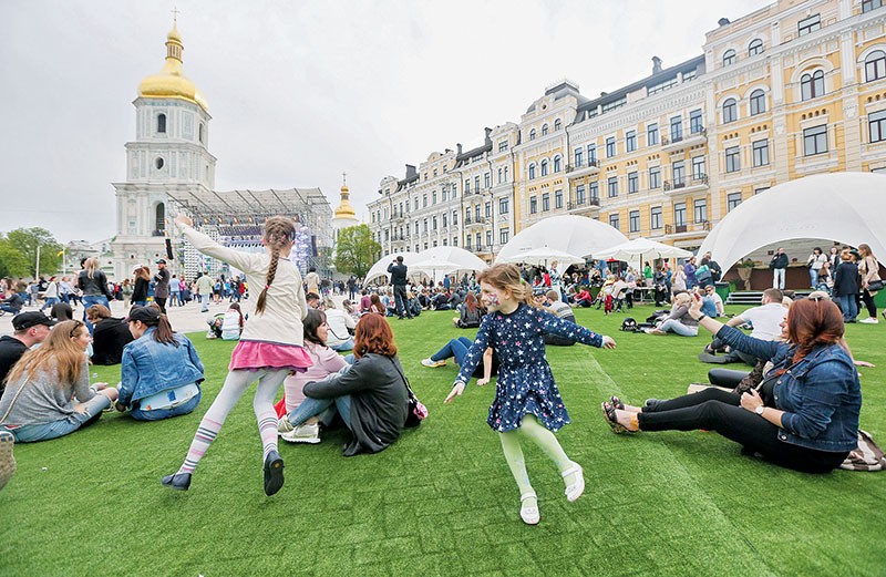 Girls play as people enjoy the opening ceremony of fan zone of Eurovision on Sofiyska Square in Kyiv on April 30.