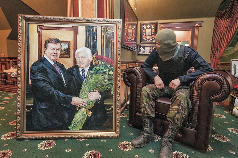 A protester rests in an armchair in the mansion of former Prosecutor General Viktor Pshonka on Feb. 24, 2014, next to his portrait with ex-President Viktor Yanukovych. Just as Pshonka was loyal to Yanukovych, current Prosecutor General Yuriy Lutsenko is seen by his critics as faithful to Ukrainian President Petro Poroshenko as the nation’s law enforcers continue to fail to stop corruption and bring justice. (Kostyantyn Chernichkin)