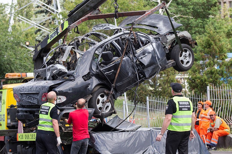 Ukrainian police tow a destroyed car away from the site of a car bomb attack in Kyiv on June 27. A senior Ukrainian military intelligence officer, Maksym Shapoval, was killed in the early-morning blast.
