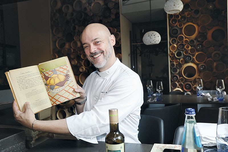 Andrea Nori, chef and owner at Casa Nori, shows an old book of original Italian recipes on May 30. (Volodymyr Petrov)