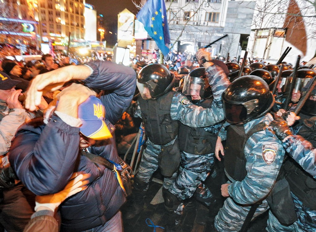 Berkut riot police officers attack anti-govenment protesters on the European Square in central Kyiv on Nov. 25, 2013. Backed by black-clad regular riot police, the blue-and-gray uniformed Berkut were involved in the most brutal attempts to suppress the protests that eventually drove former President Viktor Yanukovych from power. (Kostyantyn Chernichkin)
