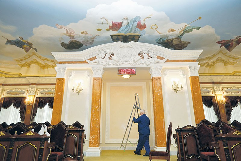 A worker carries a step ladder to change light bulbs in the session hall of the Supreme Court of Ukraine in Kyiv on April 5.