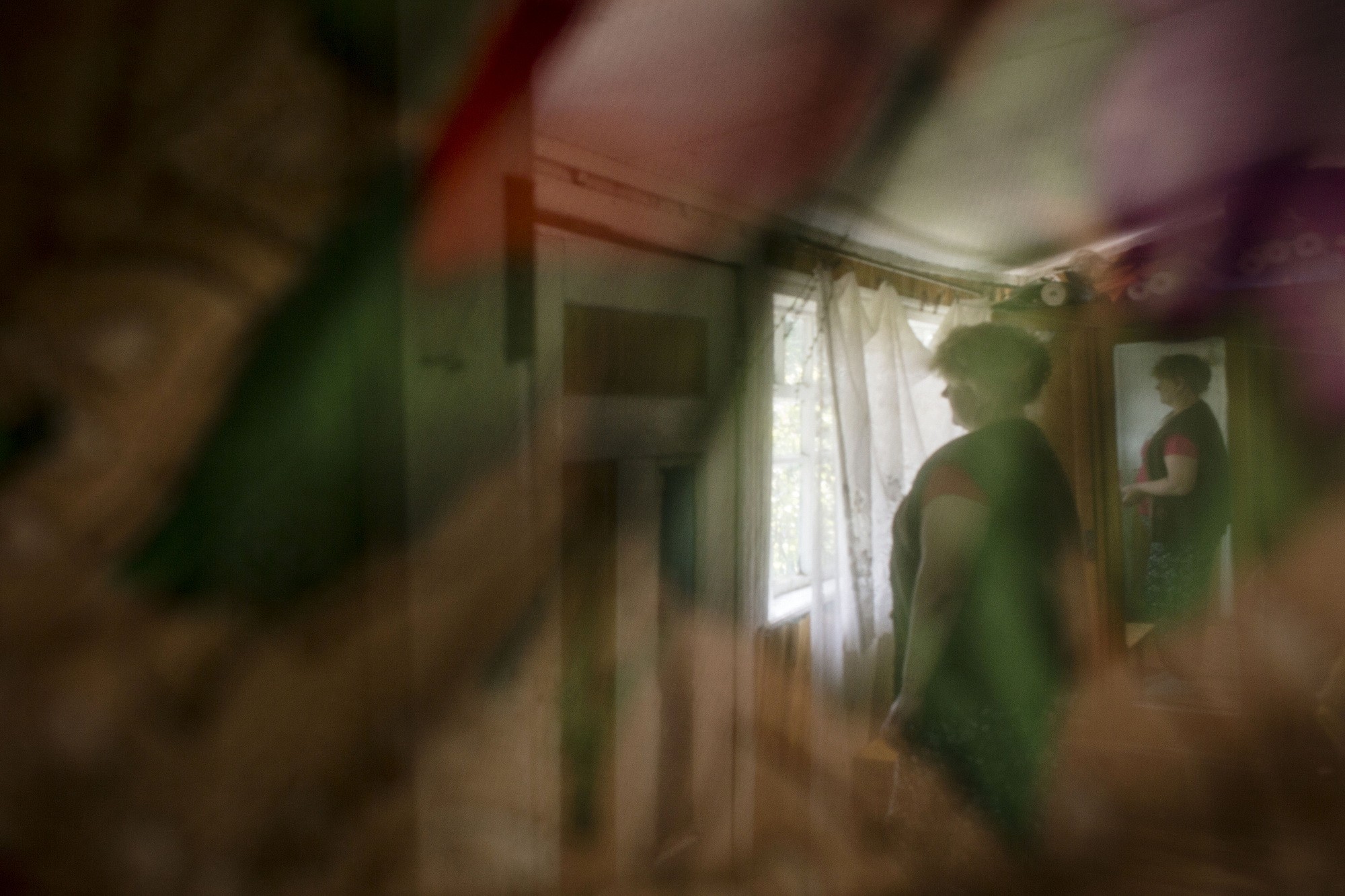 Olena Sugak looks through the window of her house in the village of Khrystophorivka in Dnipropetrovsk Oblast. For almost three years she is looking for her son Ruslan who went missing in action in August 2014.