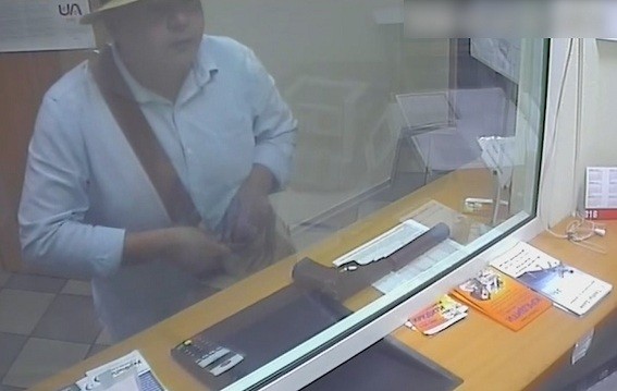 A screenshot shows a bank robber, who left candy and chocolate bars at crime scenes, caught on security camera during the robbery in a bank in 2015.