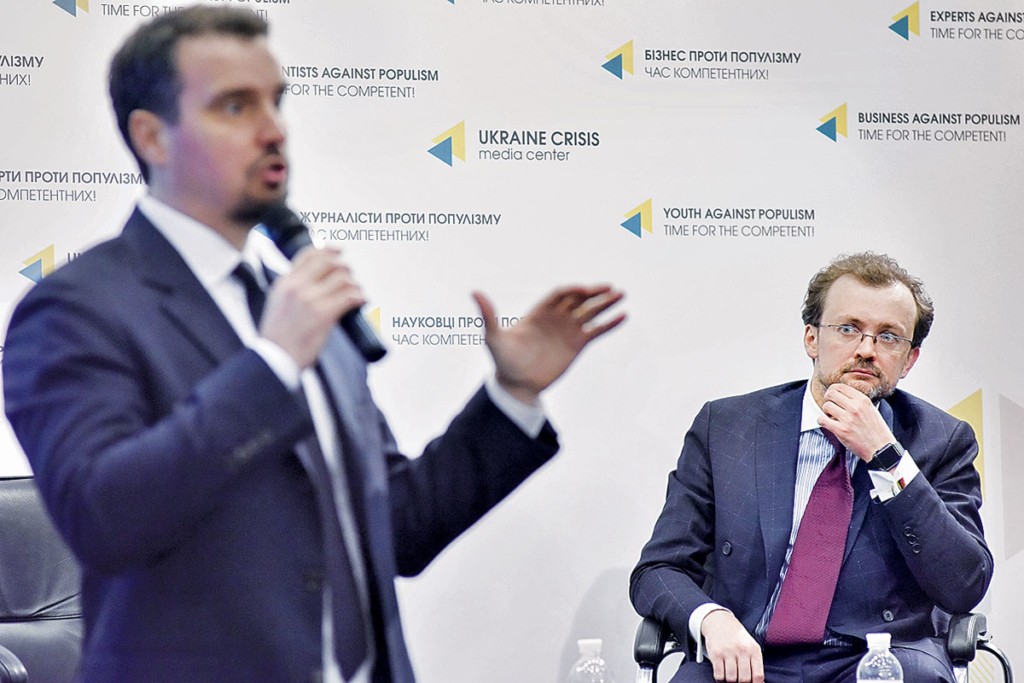 Andriy Boytsun (R) watches former Economy and Trade Minister Aivaras Abromavicius talking in Ukraine’s Crisis Media Center in Kyiv on April 21. (uacrisis.org)