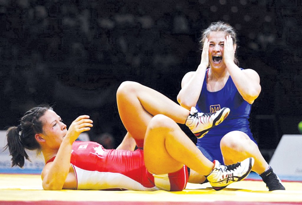 Ukraine's Alina Stadnik-Makhynia (blue) celebrates her win againts Canada's Stacie Anaka (red) during the final round of the women's free style 67 kg category of the World Wrestling Championships in Budapest on September 20, 2013. AFP PHOTO / FERENC ISZA / AFP PHOTO / FERENC ISZA