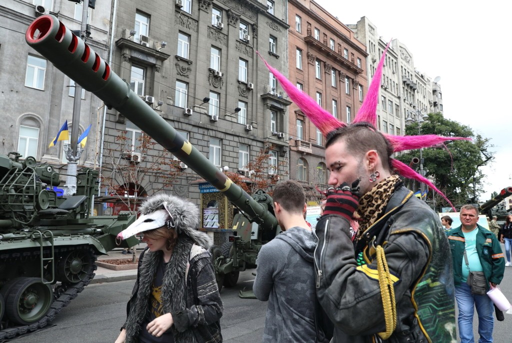 A punk-looking visitor goes along the weapons exposed in the Khreshatyk street in Kyiv on Aug. 22.