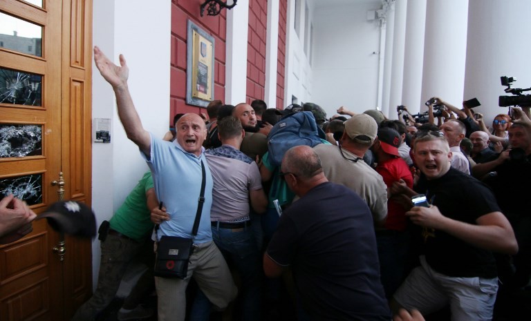 Relatives of children killed and injured at an activity camp clash with police as they storm the city hall in the resort city of Odessa demanding that the city's mayor resign on Sept. 16, 2017. 