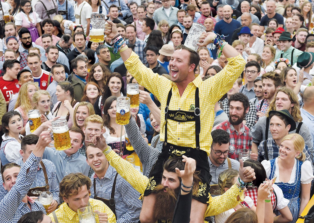 A visitor celebrates after the official opening of the 184th Oktoberfest, Munich's annual beer festival, on September 16, 2017 in Munich, southern Germany. The world's largest beer festival is held from September 16 until October 3, 2017. / AFP PHOTO / Christof STACHE