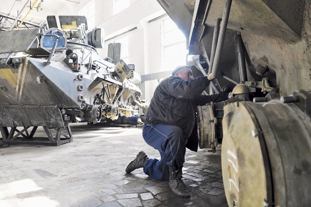 A worker repairs an armored personnel carrier’s track assembly at the Zhytomyr Armored Plant in Novoguyvinske on March 30. 