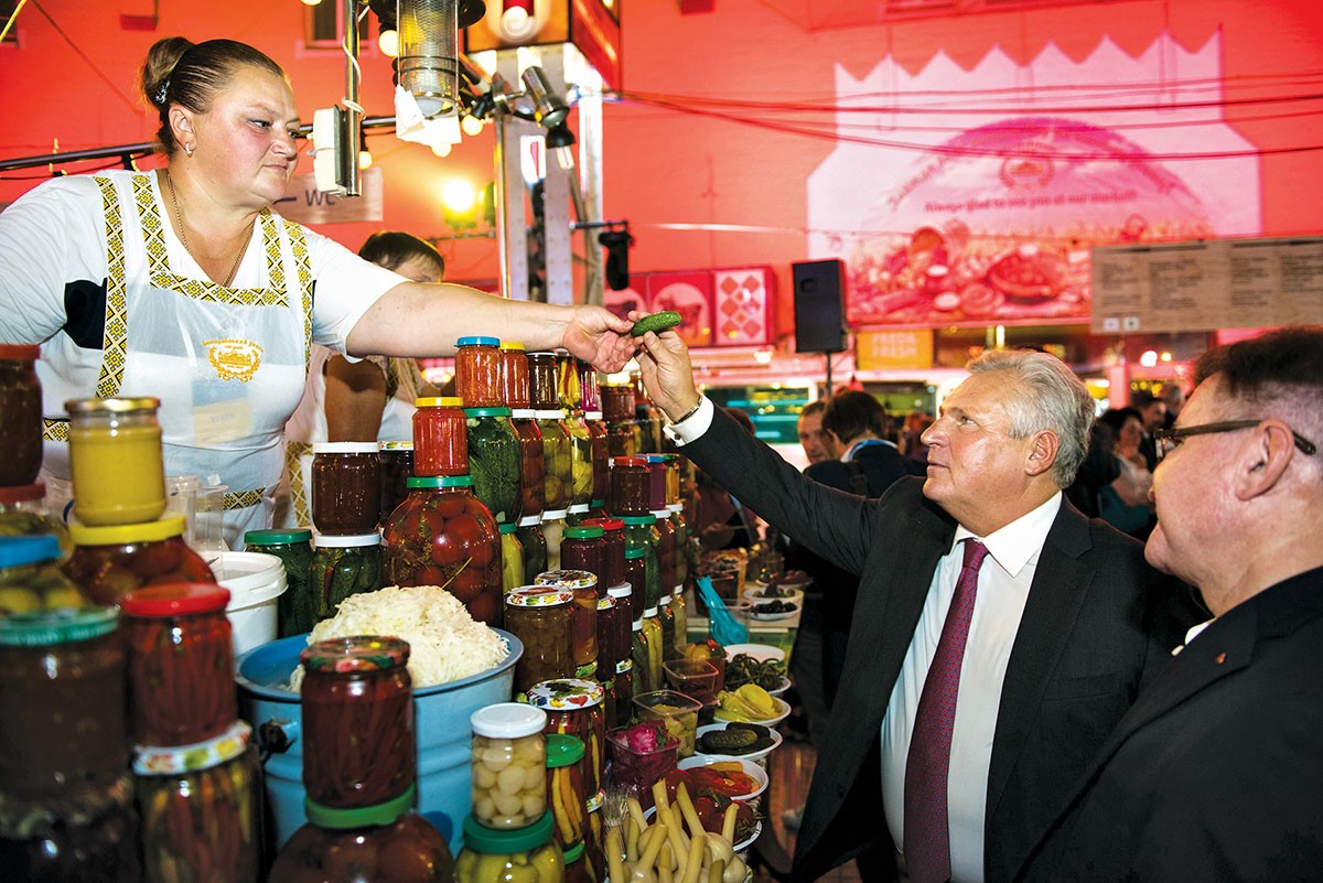 Former Polish President Aleksander Kwasniewski tries a cucumber during the welcoming reception at the Sept. 14 opening of the 14th annual Yalta European Strategy conference in Kyiv. (Sergei Illin/YES)