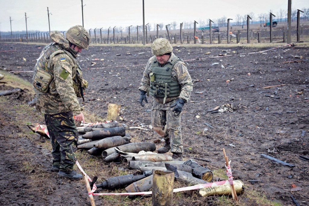 Ukrainian soldiers collect unexploded shells after a massive fire at the army depot in Balakliya on March 29. Despite huge investments made in rearmament since 2014, Ukraine’s defense industries haven’t started producing ammunition yet. 