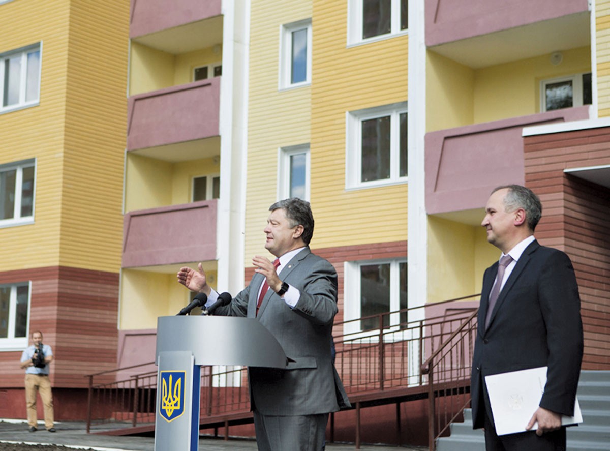 President Petro Poroshenko (L) grants keys to newly built apartments for SBU officers, standing next to SBU chief Vasyl Hrytsak on Aug. 20, 2015, in Kyiv. Critics blame Poroshenko for using the SBU, the largely unreformed successor to the Soviet KGB, to advance his political and business goals. 