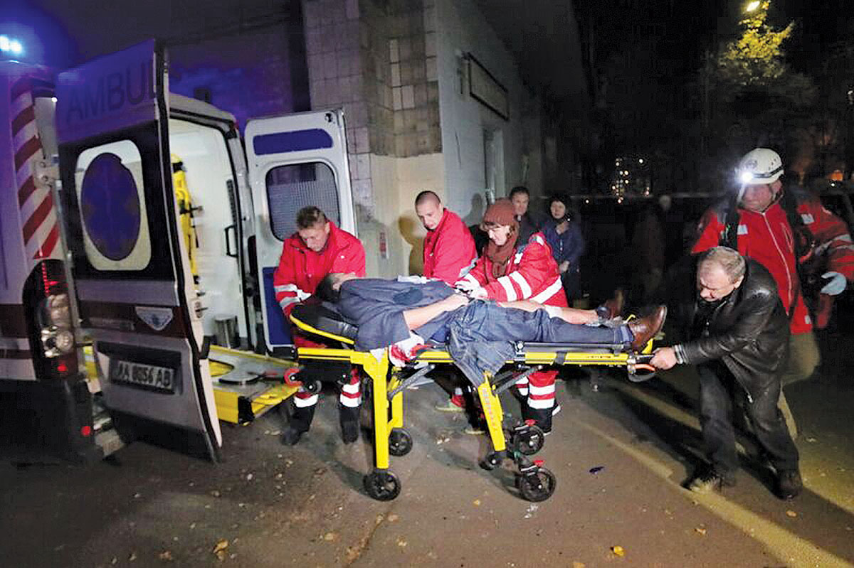 Medical workers carry a wounded person to an ambulance after the explosion in Kyiv late on Oct. 25. (AFP)