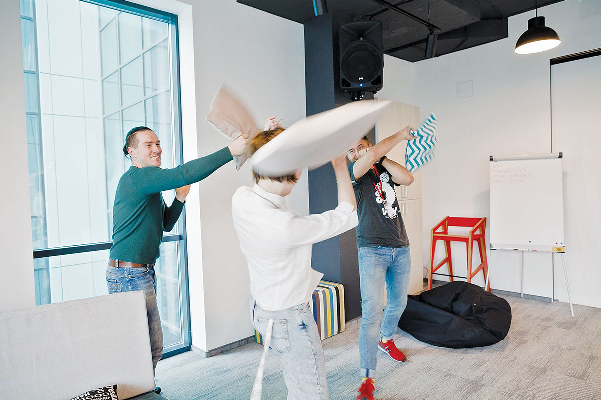 Employees of Sigma Software fight with pillows in the company’s Lviv office in March. Sigma Software CEO Valeriy Krasovskiy says tech companies tend to be much more active in corporate social responsibility than traditional firms. (Sigma Software)